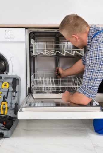 A technician repairing a dishwasher to ensure sparkling clean dishes every time.
