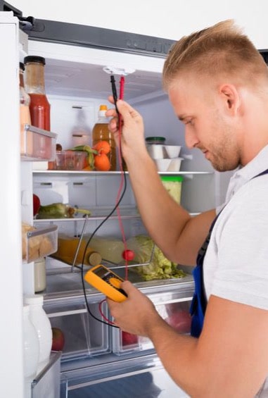 A refrigerator being repaired by a skilled technician to keep food fresh and safe.