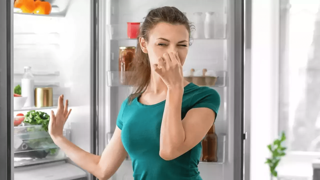 A person placing baking soda inside a refrigerator to remove odors.